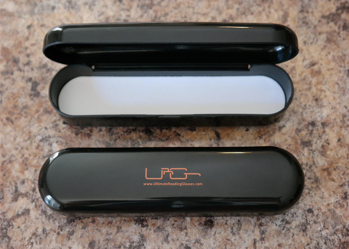 The Black Ultimate Reading Glasses hard case, resting on a table.